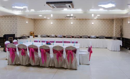 a room with a table and chairs with pink bows at The AVR Hotels & Banquets in Patna