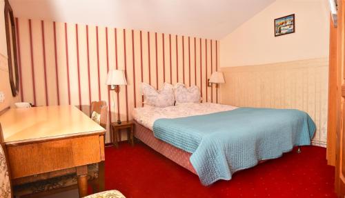 a hotel room with a bed with a blue blanket at Cichy Kącik w Karpaczu in Karpacz