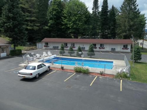 a car parked in a parking lot next to a swimming pool at Carriage House Motor Inn in Lake Placid