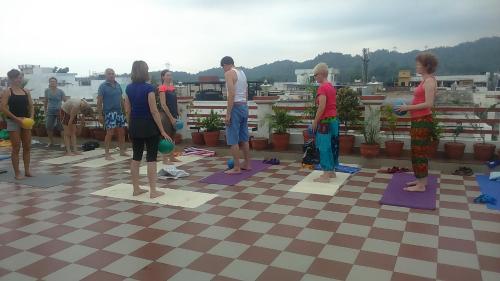 a group of people doing yoga on a roof at Hotel Krishna Ji in Haridwār