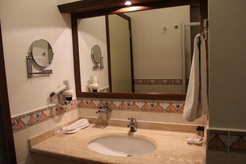 a bathroom with a sink and a large mirror at Efe Hotel Gocek in Göcek