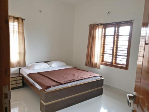 a bedroom with a bed and a window in it at BrickNest homes in Mysore