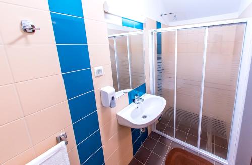 a bathroom with a sink and a shower at CVSE Clubház és Panzió in Cegléd