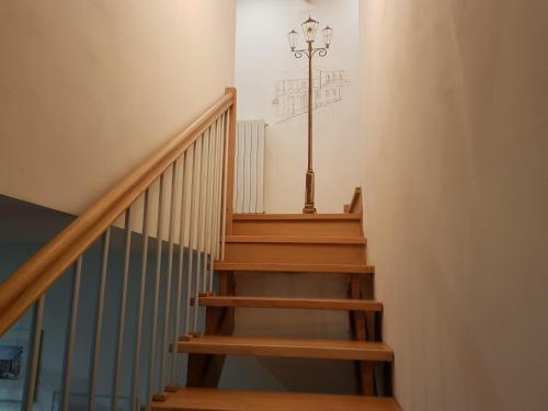 a wooden staircase with a light on the wall at La Corte B&B in Candiolo