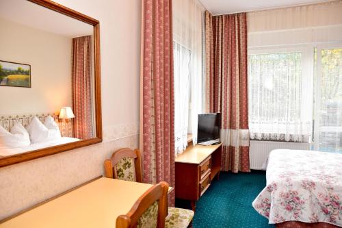 - une chambre d'hôtel avec un lit et un miroir dans l'établissement Cichy Kącik w Karpaczu, à Karpacz