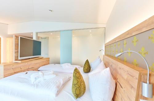 a bedroom with two beds and a flat screen tv at Vital Hotel an der Therme GmbH in Bad Windsheim