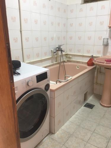 - un lave-linge dans la salle de bains à côté d'une baignoire dans l'établissement Apartment Centar, à Novi Pazar