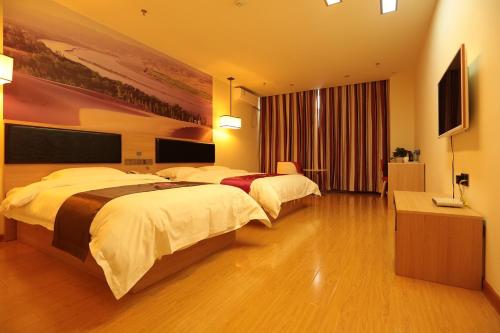 Cette chambre comprend deux lits et une télévision. dans l'établissement Thank Inn Chain Hotel Ningxia Yinchuan Xixia District Tongxin Road, à Yinchuan