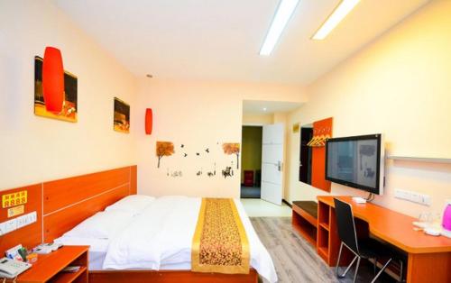 a bedroom with a bed and a desk and a tv at Thank Inn Chain Hotel Jiangsu Suqian Siyang Renmin Road in Li-k'ou-tzu
