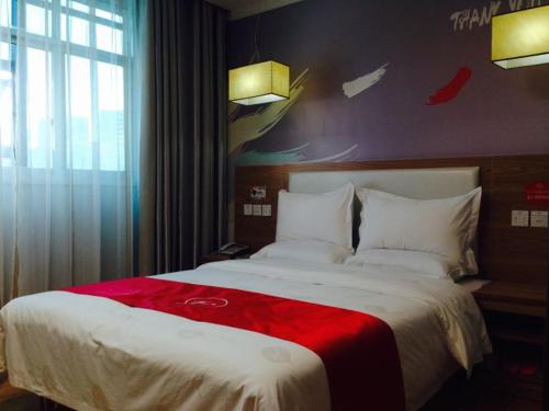 ein Schlafzimmer mit einem großen Bett mit einer roten Decke in der Unterkunft Thank Inn Chain Hotel Henan Xuchang Railway Station Qiyi Road in Xuchang