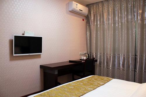 Televízia a/alebo spoločenská miestnosť v ubytovaní JUNYI Hotel Jiangsu Lianyungang South Junan Road