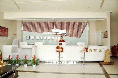 a woman standing at a counter in a hospital lobby at Thank Inn Chain Hotel Shandong Zibo Zichuan Luzhong International Shopping mall in Zibo
