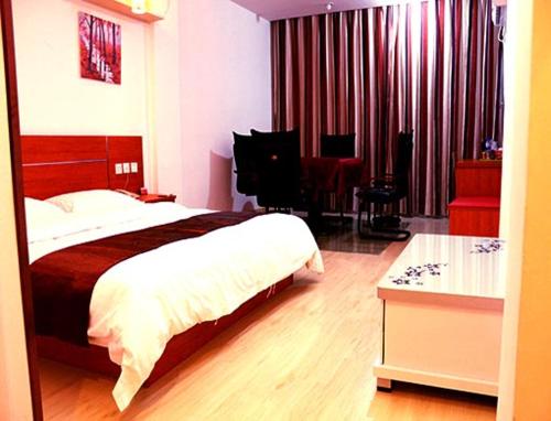 um quarto com uma cama grande e uma secretária em Thank Inn Chain Hotel Jiangsu Yancheng Jianhu Guanhua Road em Jianhu