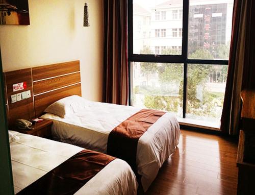 Habitación de hotel con 2 camas y ventana en Thank Inn Chain Hotel Hebei Cangzhou Qing County Nanhuan Road en Qing