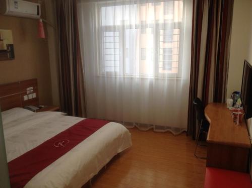 a bedroom with a bed and a window with curtains at Thank Inn Chain Hotel Hebei Langfang the 6th Street in Langfang