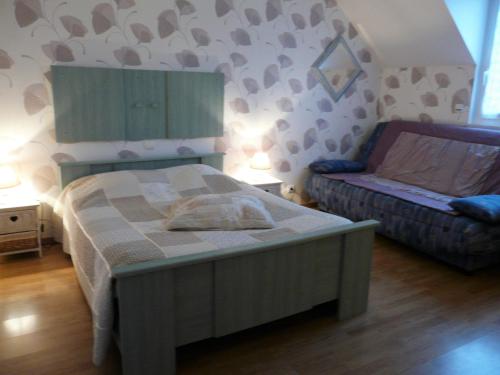 um pequeno quarto com uma cama e um sofá em Chambre d'hôtes Le Pot au Lait em Villaines-la-Juhel