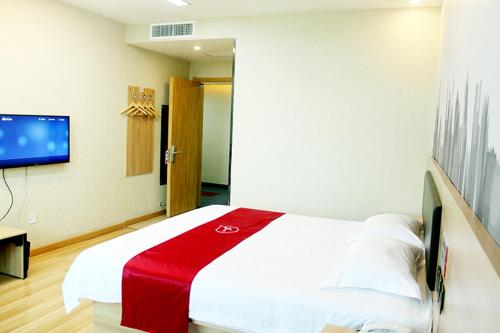a bedroom with a bed with a red blanket on it at Thank Inn Chain Hotel Hebei Shijiazhuang Xingtang Town North Yongchang Road in Jicun