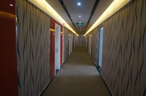 un couloir d'un immeuble de bureaux avec un long couloir dans l'établissement Thank Inn Chain Hotel Hebei Zhangjiakou Guyuan County Yingbin Avenue, à Guyuan