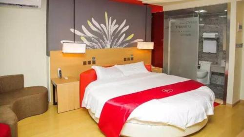 - une chambre avec un grand lit et une couverture rouge et blanche dans l'établissement Thank Inn Chain Hotel Guangdong Shanwei Haifeng County Erhuan Dongnanqiao, à Shanwei