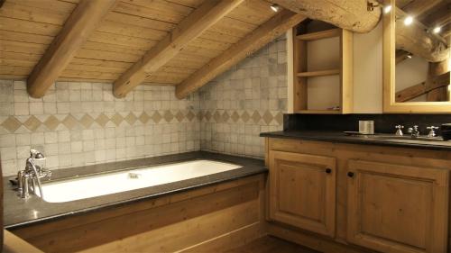 a bathroom with a tub and a sink at Chalet Geneviève in Sainte-Foy-Tarentaise