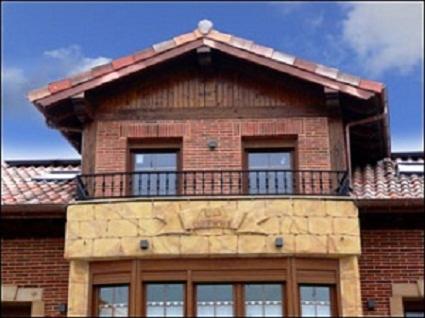 a building with a balcony on top of it at Pensión la Campanilla in La Penilla
