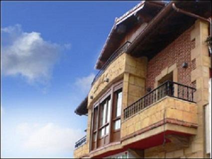 a building with a balcony on the side of it at Pensión la Campanilla in La Penilla