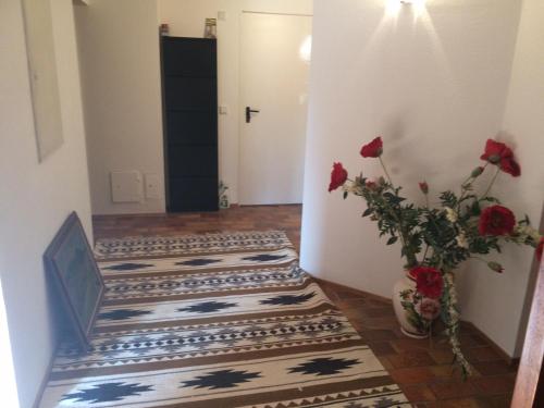 a hallway with a vase with red roses in it at schones Zimmer in Gimmeldingen/ Konigsbach in Neustadt an der Weinstraße