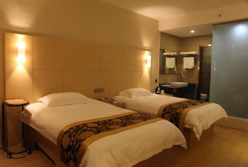 Pokój hotelowy z 2 łóżkami i umywalką w obiekcie Thank Inn Plus Hotel Shandong Qingdao Development Zone Shandong University of Science and Technology w mieście Qianwan