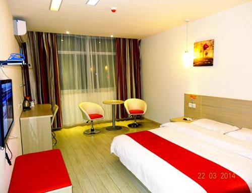 een hotelkamer met een bed, een bureau en stoelen bij Thank Inn Chain Hotel Gansu Pingliang West Huating Street Zhaozhuang in Khuatin