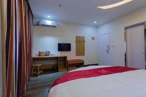 Schlafzimmer mit einem Bett, einem Schreibtisch und einem TV in der Unterkunft Thank Inn Plus Hotel Henan Luoyan Xigong District Wangcheng Avenue in Luoyang