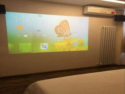 a large screen with a butterfly on a wall at Thank Inn Chain Hotel Shangxi Changzhi Daqing Road in Changzhi