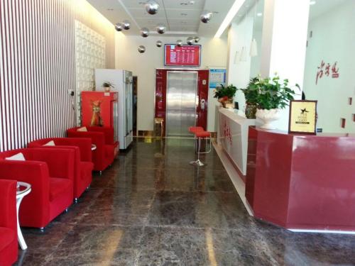 una sala de espera con sillas rojas y una puerta en Thank Inn Chain Hotel Jiangsu Yixing Dingshu Town East Jiefang Road en Zhoushu
