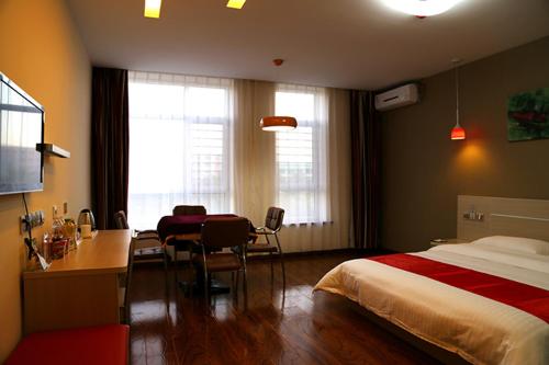 um quarto de hotel com uma cama, uma secretária e uma secretária em Thank Inn Chain Hotel Liaoning Anshan Haicheng Wanda em Yanjun