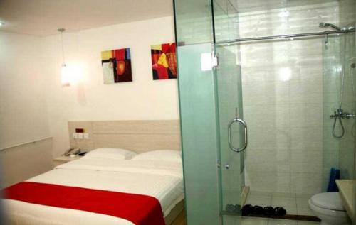 a bathroom with a bed and a glass shower at Thank Inn Chain Hotel Hebei Cangzhou West Jiefang Road in Cangzhou