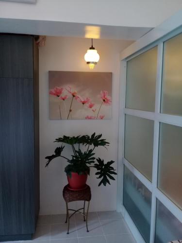 a potted plant in a room with a painting on the wall at Miguel's Place at Tagaytay Prime Residences in Tagaytay
