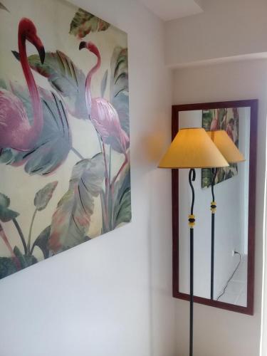a lamp next to a wall with a painting of flamingos at Miguel's Place at Tagaytay Prime Residences in Tagaytay