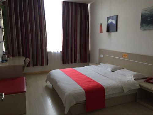 een slaapkamer met een bed met een rode en witte deken bij Thank Inn Chain Hotel Gansu Pingliang West Huating Street Zhaozhuang in Khuatin