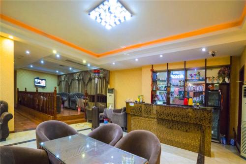 a restaurant with a bar with a table and chairs at Thank Inn Chain Hotel Sichuan Guangan Wusheng County Hongwu Avenue in Wusheng