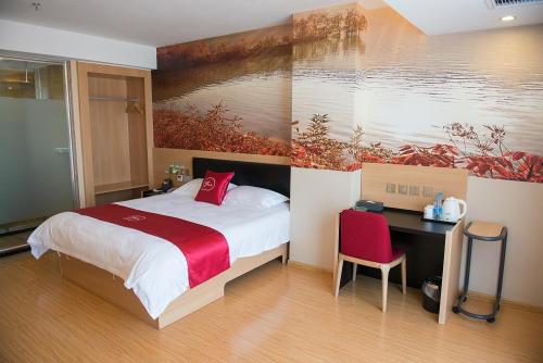 Thank Inn Plus Hotel Sichuan Neijiang Hongxing Red Star Macalline في Neijiang: غرفة نوم بسرير ومكتب ولوحة