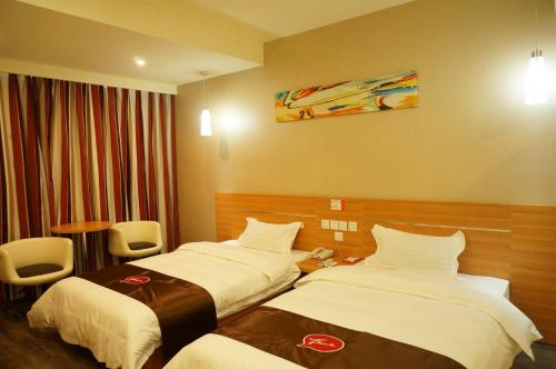 Thank Inn Chain Hotel Hunan Loudi New Huaxuefu Road في Dongling: غرفه فندقيه سريرين في غرفه