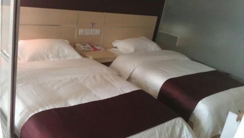 two beds in a hotel room with at Thank Inn Chain Hotel Jiangsu Nantong Jiuwei Bay in Nantong