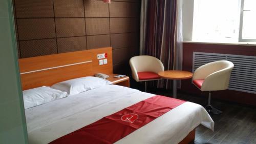 a hotel room with a bed and two chairs and a table at Thank Inn Chain Hotel Shanxi Lvliang County Taihe North Road in Houganquan