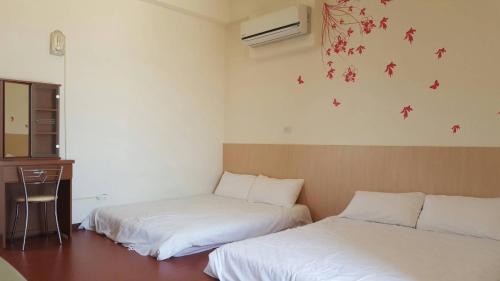 1 Schlafzimmer mit 2 Betten, einem Schreibtisch und einem Fenster in der Unterkunft Dong Wang Homestay in Taitung