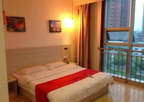 um quarto com uma cama e uma grande janela em Thank Inn Chain Hotel Shandong Shouguang New Bus Station em Shouguang