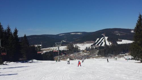a group of people skiing down a snow covered slope at Chata Ramzovské sedlo in Ramzová