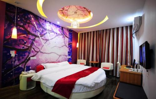 1 dormitorio con 1 cama grande y una pared colorida en Thank Inn Chain Hotel Guizhou Anshun Development Area Xihang Road, en Anshun