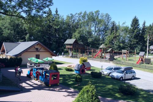 a park with a playground with cars and a building at Chata Ramzovské sedlo in Ramzová