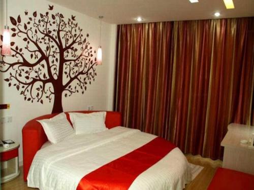 1 dormitorio con 1 cama con un árbol en la pared en Thank Inn Chain Hotel Hebei Cangzhou West Jiefang Road en Cangzhou
