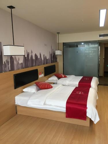 duas camas com lençóis vermelhos e brancos num quarto em Thank Inn Chain Hotel Sichuan Dazhou Tongchuan Dis. Railway Station em Dazhou