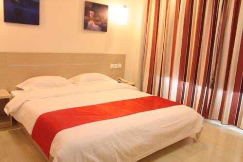 een slaapkamer met een bed met een rode en witte deken bij Thank Inn Chain Hotel Gansu Pingliang West Huating Street Zhaozhuang in Khuatin